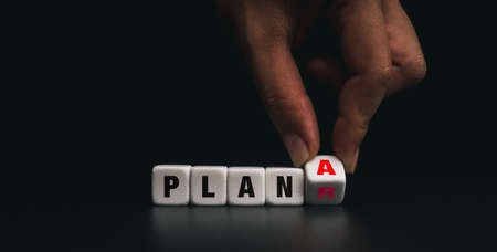 Hand flipping the white dice blocks with plan A change to backup plan B on dark background. Concept of problem solving, strategy, analysis, marketing.の写真素材