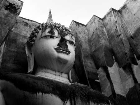 Close-up face of ancient big buddha statue inside the old church at Wat Sri Chum Temple, the famous landmark in at Sukhothai Historical Park, a UNESCO World Heritage Site in Thailand, black and white.のeditorial素材