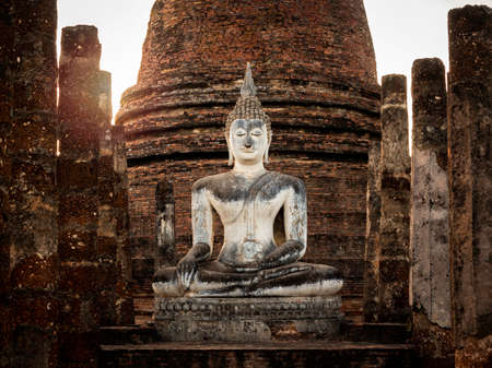 Amazing scene of big buddha statue and old ancient structure at Wat Mahathat Temple in the precinct of Sukhothai Historical Park, a UNESCO World Heritage Site in Thailand.のeditorial素材