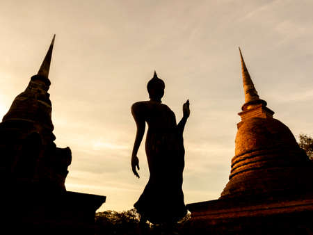 Amazing scene of silhouette of buddha statue and old ancient pagoda at Wat Sra Sri And Tra Pang Tra Kuan temple in the precinct of Sukhothai Historical Park, a UNESCO World Heritage Site in Thailand.のeditorial素材
