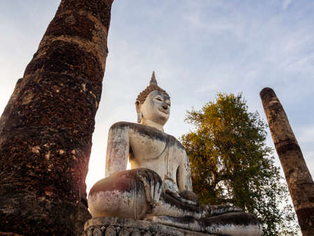 Amazing scene of big buddha statue and old ancient structure at Wat Mahathat Temple in the precinct of Sukhothai Historical Park, a UNESCO World Heritage Site in Thailand.のeditorial素材