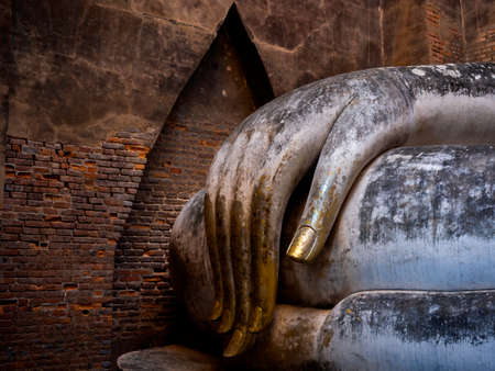 Close-up huge hand of ancient buddha statue inside the church at Wat Sri Chum Temple, the famous landmark in at Sukhothai Historical Park, a UNESCO World Heritage Site in Thailand.のeditorial素材