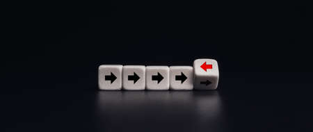 Leadership, unique, think different way concept.  White dice blocks flipping with red arrow facing the opposite direction black arrows on dark banner background, minimal style.の写真素材