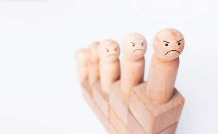 The business goal with growth success process for Leadership concept. Close-up determined face on the wooden figure as a businessman on wood cube block chart steps on white background with copy space.の写真素材