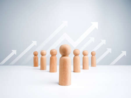 Leader wooden figures with followers lineup in orderly on white background with growth up arrows. Leadership concept, manager, CEO, market leader, Influencer, opinion lead, and business leading.の写真素材