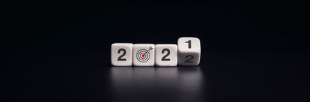 2022 Happy New year banner with business goal and success concept. Flipping of black dice blocks for change numbers from 2021 to the new year 2022 on dark background, modern and minimal style.の写真素材