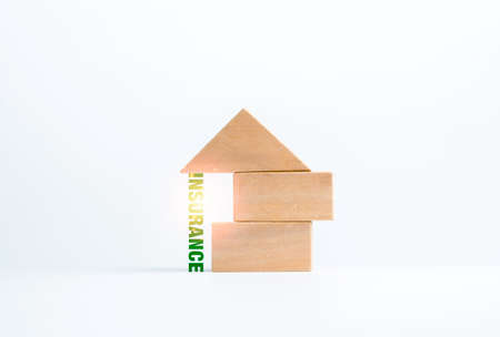 Insurance, word supporting under the wooden block stack, house shape on white background, minimal style. Property, family insurance protection concept.の写真素材