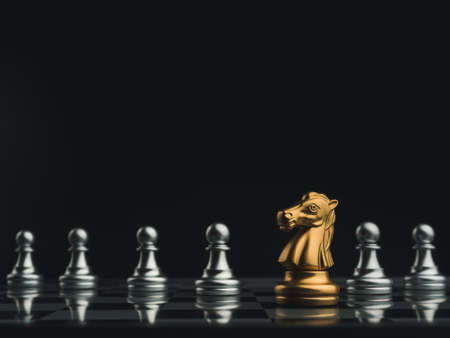 The golden horse, knight chess piece standing in front of silver pawn chess pieces on chessboard on dark background. Leadership, follower, team, commander, competition, and business strategy concept.の写真素材