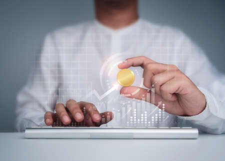 Investment, profit and business growth concept. Businessman in white shirt holding golden coin with...