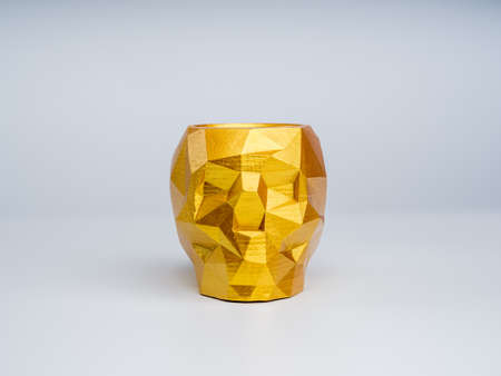 Empty gold color skull shape plant pot isolated on white background. Small modern DIY cement planter...