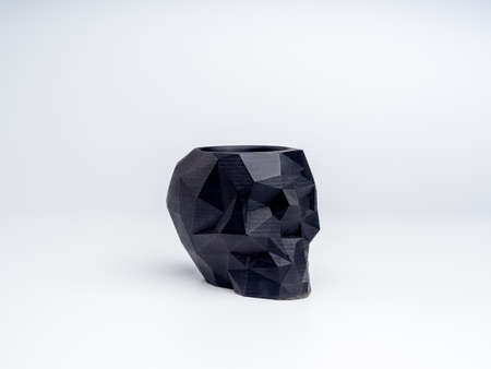 Empty black skull shape plant pot isolated on white background. Small modern DIY cement planter trendy decoration.の写真素材