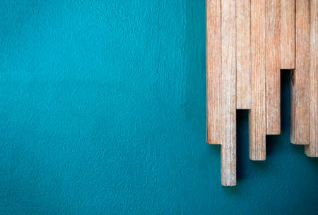 Close up minimal style background with a row of wood sticks arranged as a chart step on the blue color concrete wall surface with copy space.の写真素材