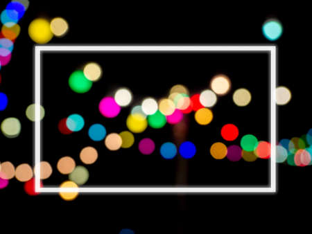 White square border frame with blank space on abstract blurred image of colorful light of night party bokeh on dark background. Template on blurry festival and celebration bokeh background.の写真素材