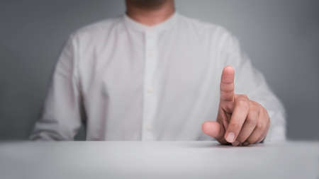 Finger touch on virtual touch screen gesture by business person in white shirt sitting behind the...