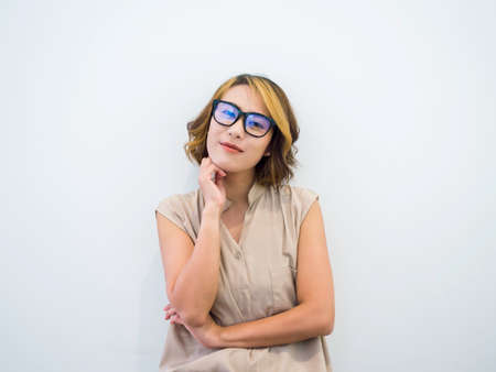 Happy smiling Asian woman short hair in black eyeglasses and beige sleeveless shirt posing with...