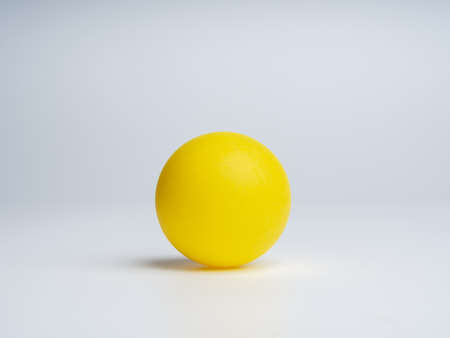 Yellow ball isolated on white background with space for logo templates, icon background, photography studio shot. A clean yellow circle sphere with shadow on the ground.の写真素材