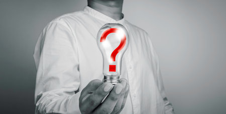 The red question mark icon in the light bulb in human hand on white background, black and white...