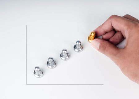 The golden pawn chess piece moves up by hand from the silver pawn chess pieces as a chart steps on...