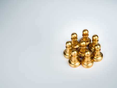 The golden pawn chess pieces standing together on white background with copy space. Strong, Leadership, unique, unity and teamwork concept.の写真素材