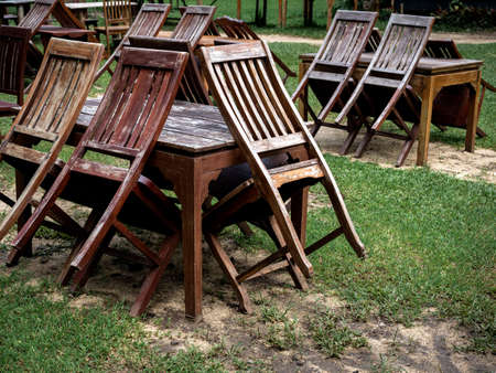 Empty old abandoned wooden dining table set on the green yard garden. Outdoor restaurant permanently...