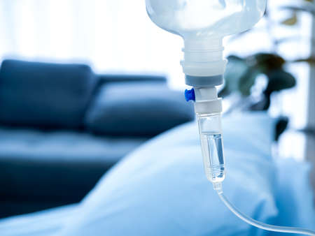 Close up of set vitamin iv fluid intravenous drip saline drop near the patient bed in hospital room...
