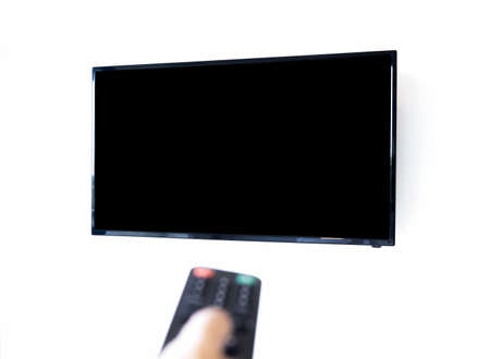 View of mockup black blank space on TV screen isolated on white wall background with blurred focus...