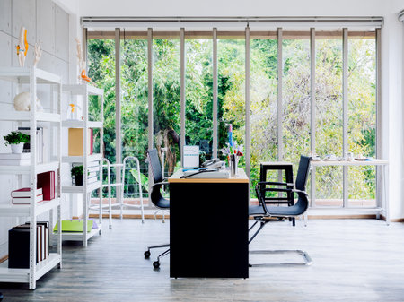 Orthopedic doctor office background decorated with desk and chairs, tools and medical equipment on table, skeleton model and books on bookshelves near the huge glass window. Interior of modern clinic.の写真素材