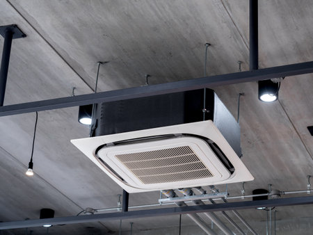 Ceiling mounted cassette type air conditioner decoration near the spot lights on the concrete construction building, loft style interior. Ceiling type of air conditioning unit with ventilation system.の写真素材