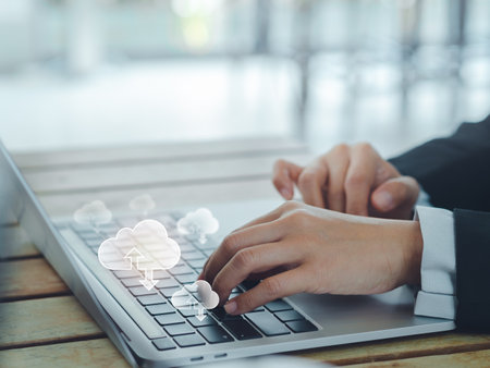 Cloud technology concept. Small cloud icons appearing on laptop computer while business people working with laptop computer with copy space. Data storage security, digital privacy secure on internet.の写真素材