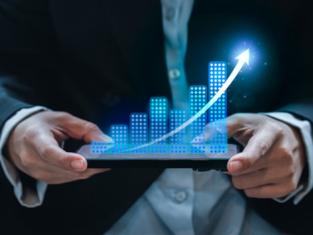 Investment technology, financial, return on investment - ROI concepts. Increasing arrow, the exponential progress in business performance over charts on mobile smart phone in business person's hands.の写真素材