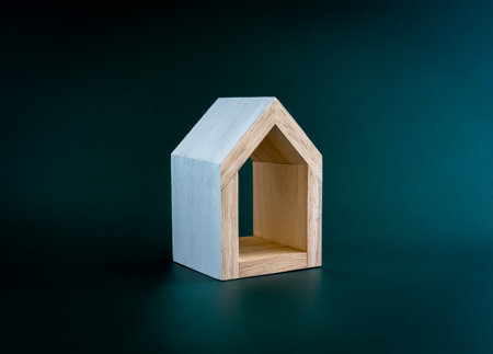 Home, house, family, real estate, property concepts. White minimal miniature wooden small house isolated on dark green background.の写真素材