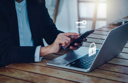 Two steps authentication (2FA) concept. Key icon and password code showing on smart phone while businessperson login on laptop computer, Identity verification, cybersecurity technology.の写真素材