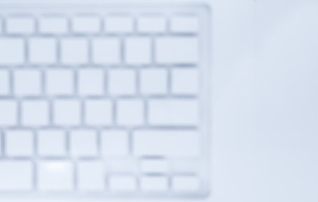 Blurred abstract background of white clean keyboard laptop computer with copy space, top view....