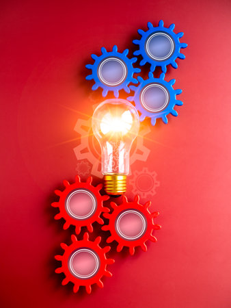 Shining light bulb connected between blue and red gear wheels on red background, vertical style. Business strategy, management and solution, human research, connection, teamwork and idea concepts.の写真素材