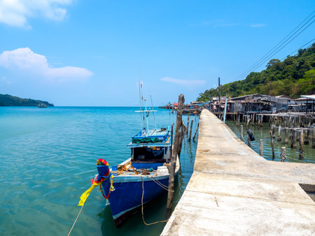 Ao Yai village, Koh kood, trat, Thailand. Scene of wooden boat near the bridge and fisherman village in the blue sea and green mountain with beautiful view with open sky on summer sunshine day.の写真素材