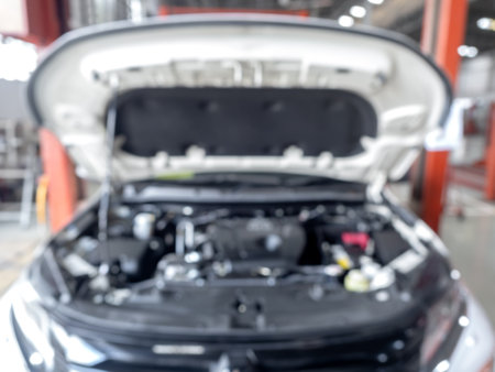 Abstract blur of engine inside bonnet hood car garage automobile interior building. Blurred mechanic service centre auto repair workshop, soft defocused. Blurry car care station background.の写真素材