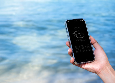 Weather forecast on smartphone. Clear weather, display app on Friday with temperature number, cloud...