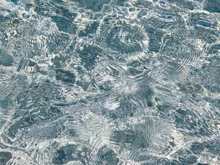 Light clear blue sea water background. Swimming pool surface with bright and clean water movement,...