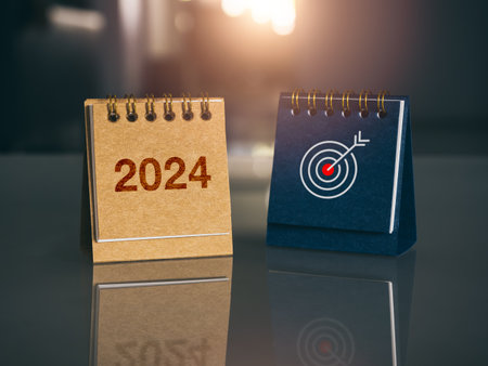 Happy new year 2024 banner background. 2024 number year with target icon on brown and blue small desk calendar cover standing on glass table with new day sunlight. Business goals and success concepts.の写真素材