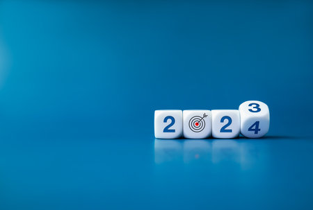 2024 happy new year with the goal and successful concepts. Flipping the 2023 to 2024 year numbers calendar with goal target icon on white cube blocks on dark blue  banner background with copy space.の写真素材