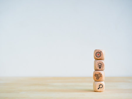 Business strategy and action plan icon on four wooden cube blocks stack isolated on wood shelf and white background with copy space. Objective, goal and success, management process, startup concepts.の写真素材