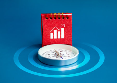 Investment direction, goals plan and investment trends concept. Business growth graph icon on red desk calendar cover standing near compass on blue background with target dart symbol, minimal style.の写真素材