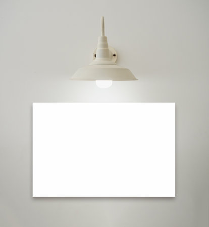 Mockup horizontal white blank artwork or picture frame under the hanging vintage glowing light lamp on white background, minimal style. Template photo or painting with lighting decoration on the wall.の写真素材