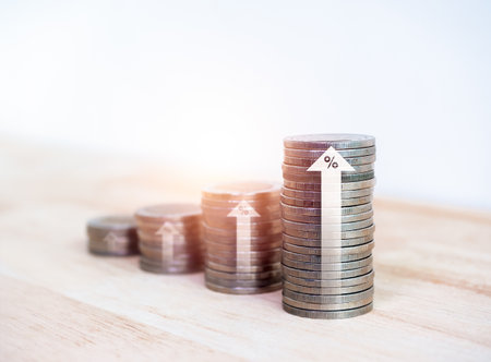 Investment, growth financial business, Increase earning money, income and sales profit concept. Rising up arrows with percentage icon on coin stack, graph chart step on wood desk and white background.の写真素材