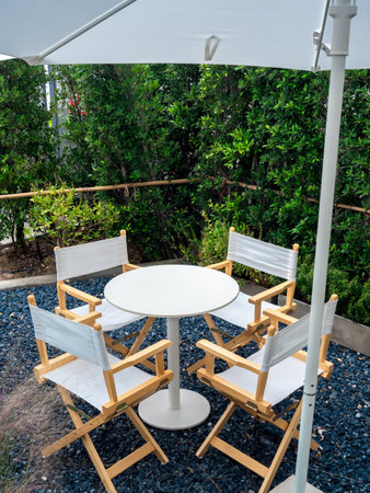 Four empty director chairs, fabric and wood materials with round shape table at outdoor garden on...