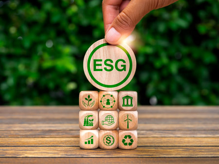 Environmental, social, and corporate governance (ESG), environment sustainable for save the earthconcept. Acronym text "ESG" in hand put on wood cube with icons on wood block stack, green background.の写真素材