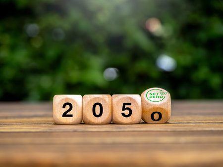 2050 year number on flipping block with green net zero icon on green leaves background. Net zero by 2050. Reduce CO2 emissions, carbon dioxide reduction, limit climate change, global warming concepts.の写真素材