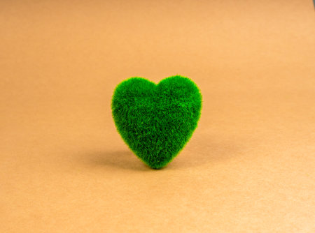 Green heart shaped ball covered with grass isolated on brown recycled paper background. Environment care sustainable and planet protection, Eco-friendly, conservation, and Happy Earth Day concept.の写真素材