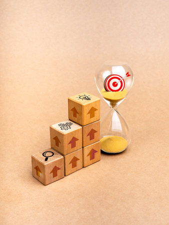 Business success process and marketing goal strategic concepts. 3d Target icon in hourglass near wooden cube blocks growth graph steps with rise arrow, strategy management symbols, minimal background.の写真素材