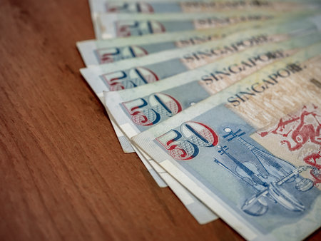 Singapore dollar money background. Several Close-up 50 Singapore dollars currency banknote bills were unfolded on wooden table background. Business finance and banking concept.の写真素材